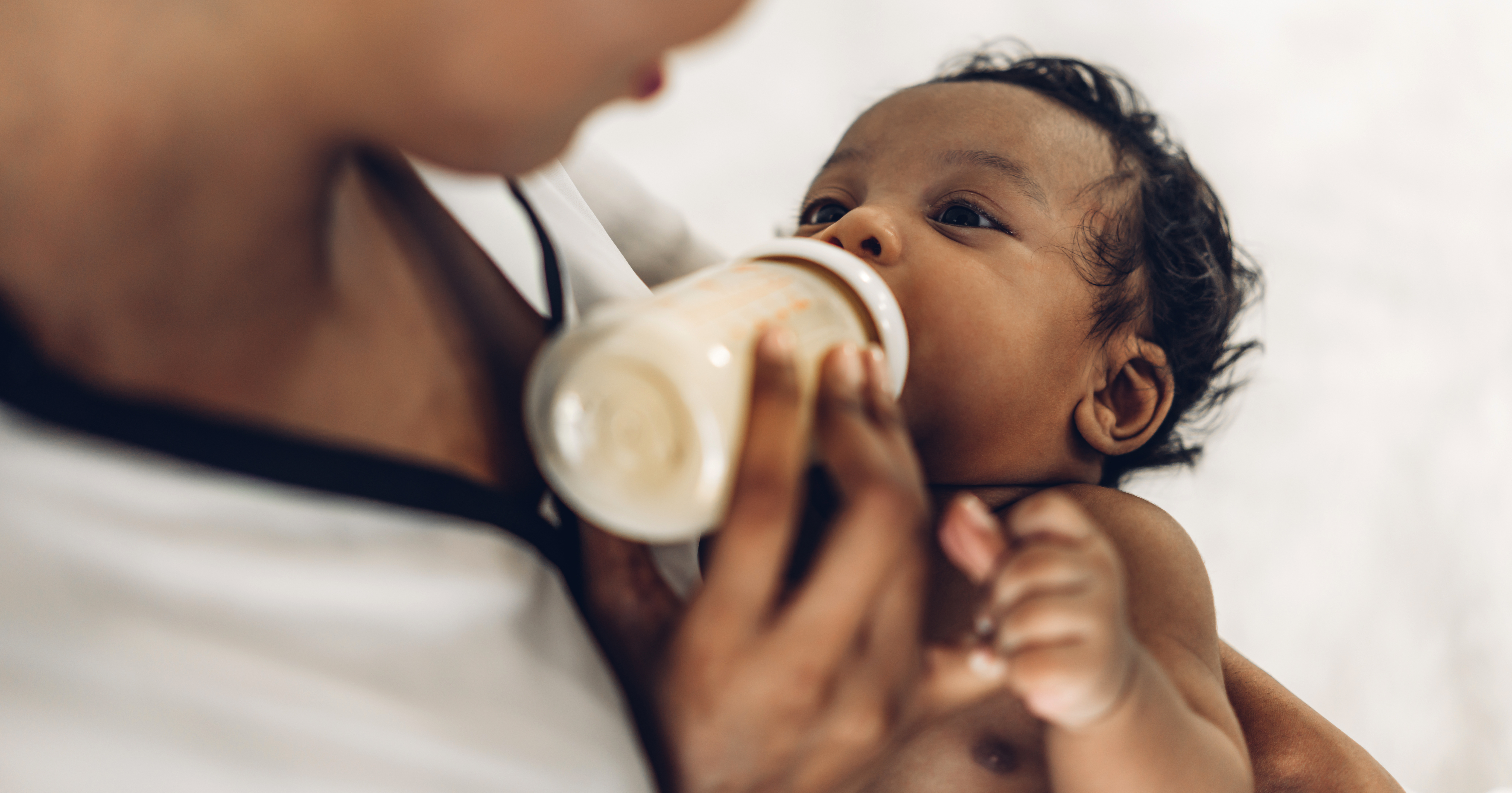 Photo of a mother giving a bottle to a baby.